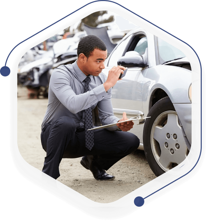 A man in a suit and tie working on his car tire.